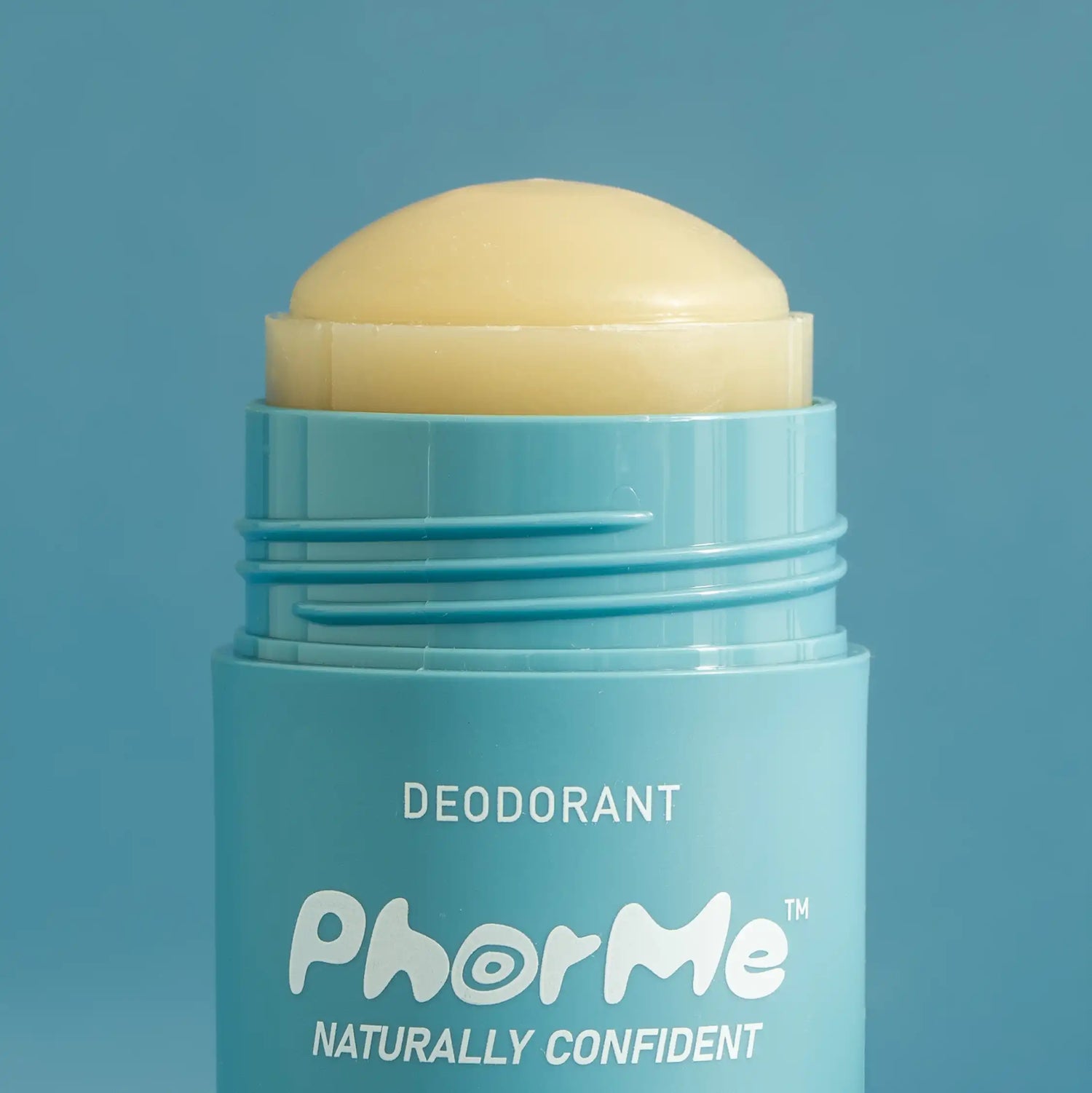 Close-up of PhorMe unscented natural deodorant stick with the balm extended, showing creamy texture and teal packaging against a blue background. Aluminum-free, gentle deodorant made for every body.