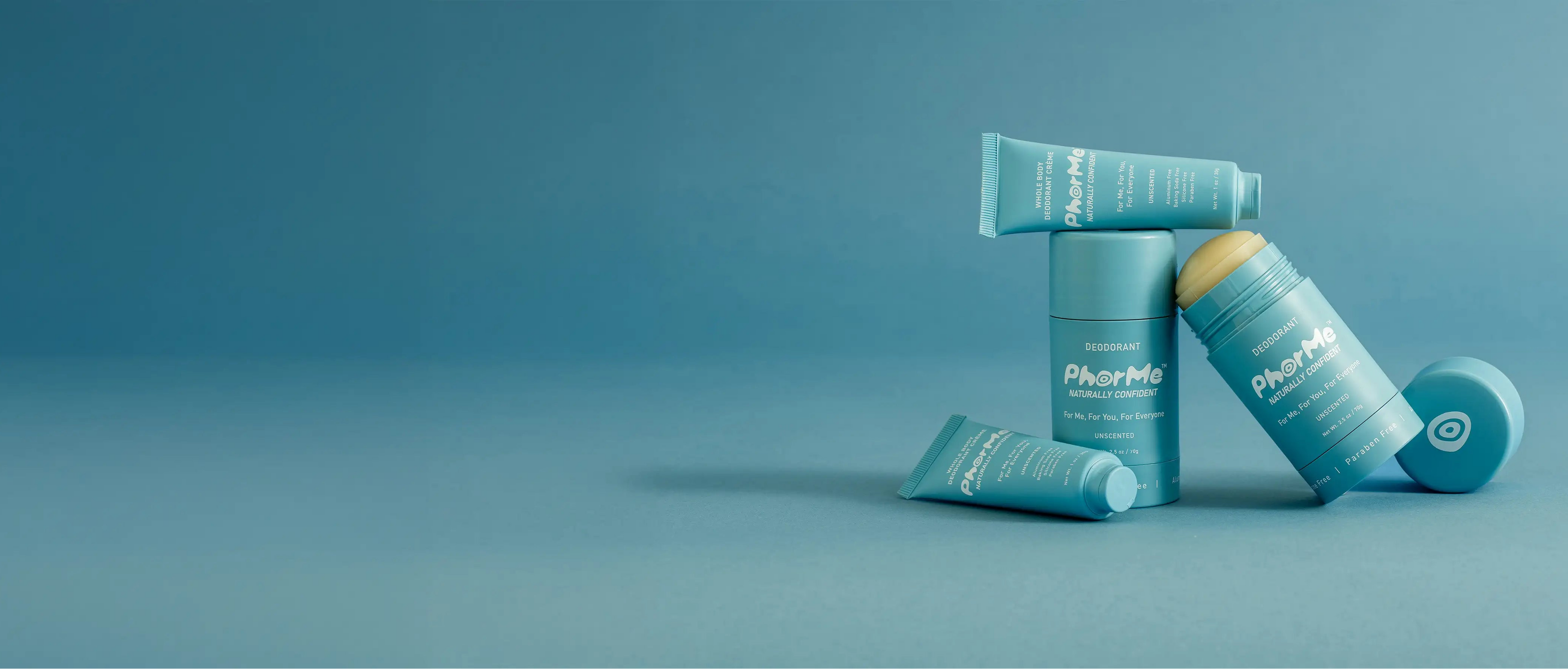 PhorMe unscented natural deodorant in stick and travel-size tube packaging, displayed on a blue background. Aluminum-free, baking soda-free deodorant designed for every body.
