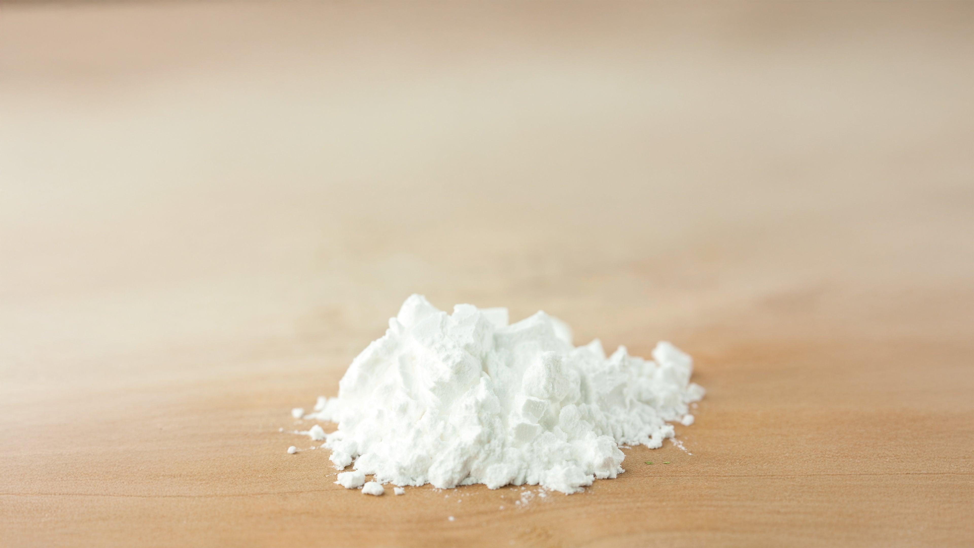 Close-up of arrowroot powder on a wooden surface. A natural, gentle ingredient used in deodorant to absorb moisture and keep skin dry without irritation.